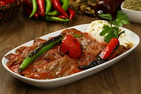  İskender Kebap: A Flavorful Symphony of Juicy Meat, Tangy Tomato Sauce, and Creamy Yogurt